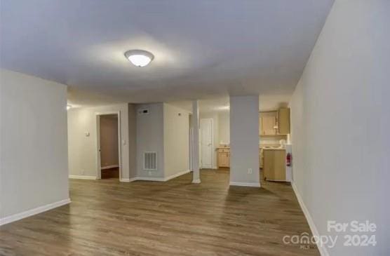 unfurnished room with dark wood-type flooring