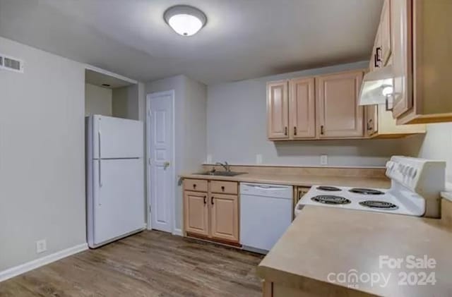 kitchen with custom range hood, white appliances, light wood-type flooring, light brown cabinetry, and sink