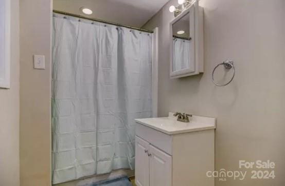 bathroom featuring walk in shower and vanity