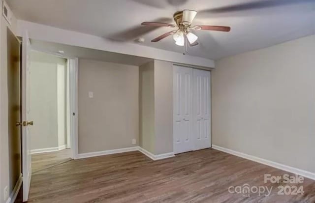 unfurnished bedroom with ceiling fan, a closet, and hardwood / wood-style floors