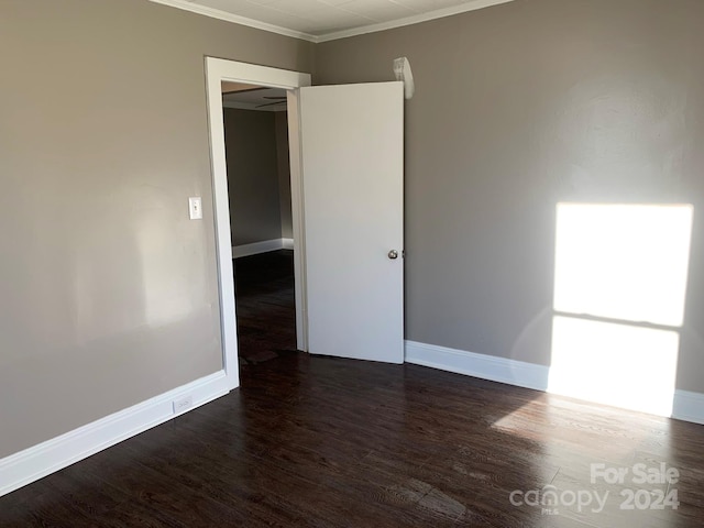 unfurnished room featuring dark hardwood / wood-style floors and ornamental molding