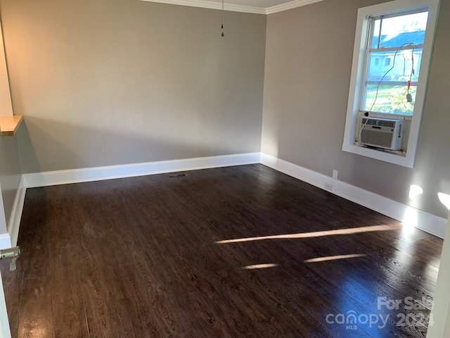 unfurnished room featuring cooling unit, ornamental molding, and dark hardwood / wood-style flooring