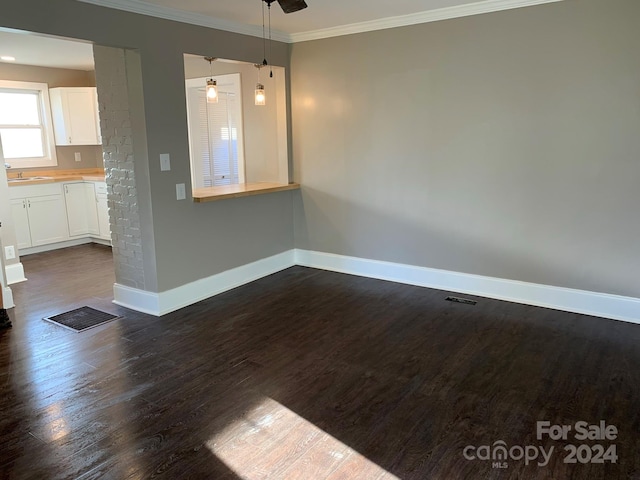 interior space featuring ceiling fan, sink, dark wood-type flooring, and crown molding