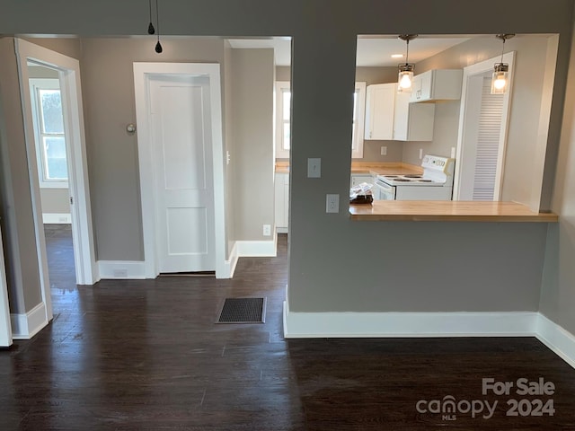 kitchen featuring kitchen peninsula, decorative light fixtures, white electric stove, and dark hardwood / wood-style flooring