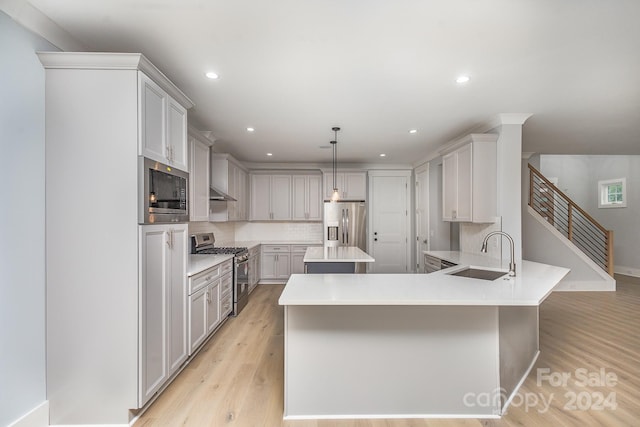 2305 Sanders Ave, Charlotte, NC 28216 - kitchen featuring light wood-style flooring, a sink, tasteful backsplash, and appliances with stainless steel finishes