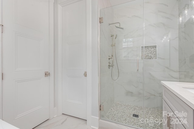 bathroom with a shower with door and vanity