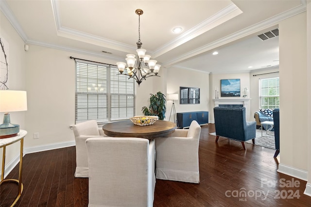 dining space featuring a tray ceiling, ornamental molding, dark hardwood / wood-style floors, and a chandelier