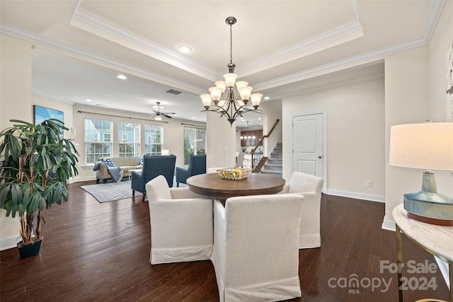 dining space with ceiling fan with notable chandelier, crown molding, dark hardwood / wood-style floors, and a raised ceiling