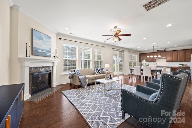 living room with a high end fireplace, ornamental molding, dark hardwood / wood-style floors, and ceiling fan