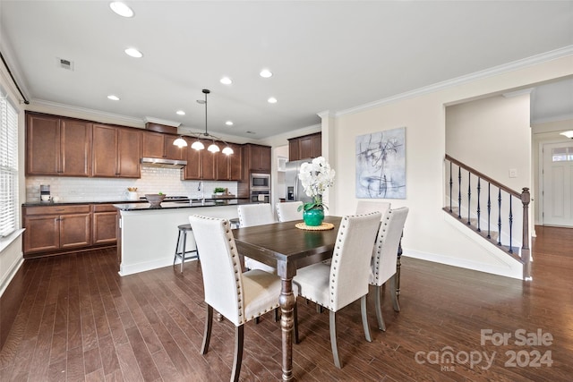 dining area featuring sink, dark hardwood / wood-style floors, and ornamental molding