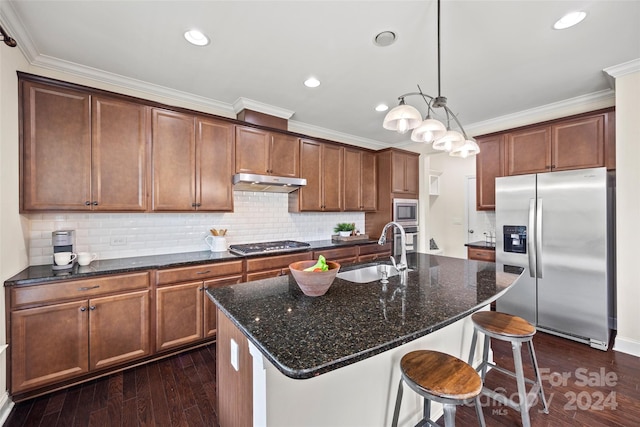 kitchen featuring sink, a kitchen island with sink, stainless steel appliances, dark hardwood / wood-style floors, and dark stone counters