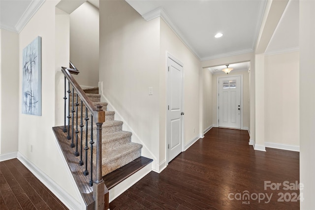 foyer entrance with crown molding and dark hardwood / wood-style flooring