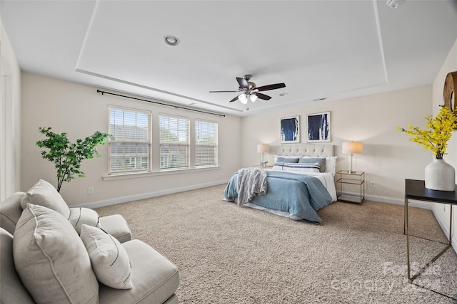 bedroom featuring carpet, a tray ceiling, and ceiling fan