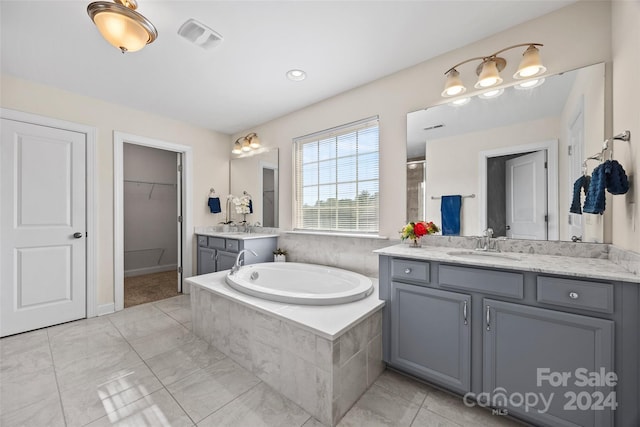 bathroom featuring independent shower and bath, vanity, and tile patterned flooring