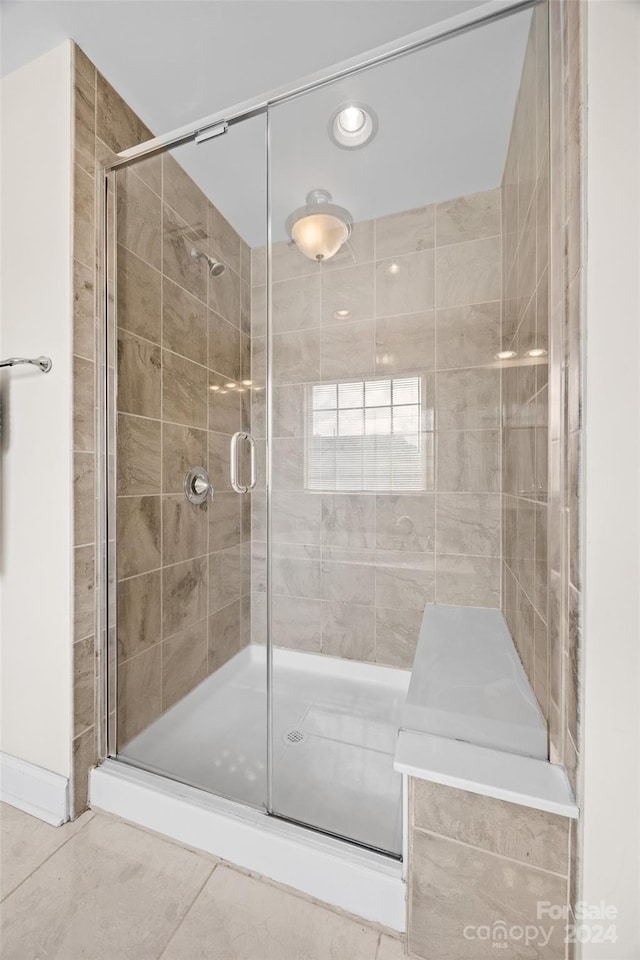 bathroom featuring a shower with shower door and tile patterned floors