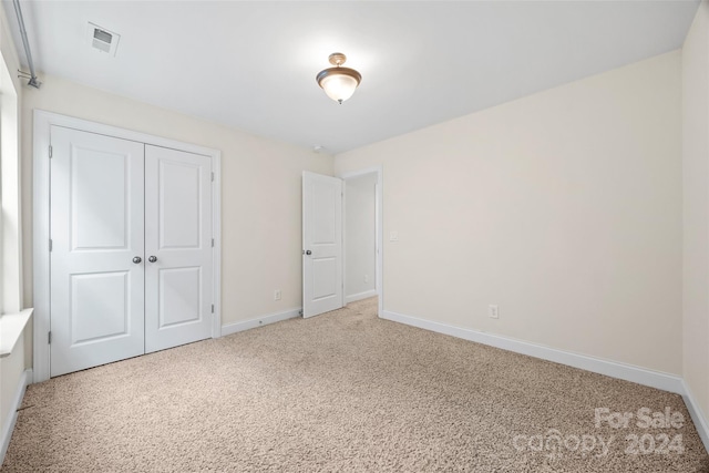 unfurnished bedroom featuring a closet and carpet flooring