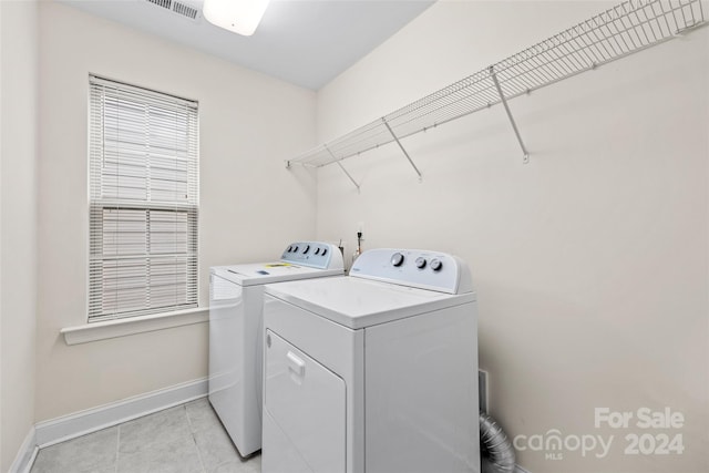 laundry area featuring light tile patterned floors and washing machine and dryer