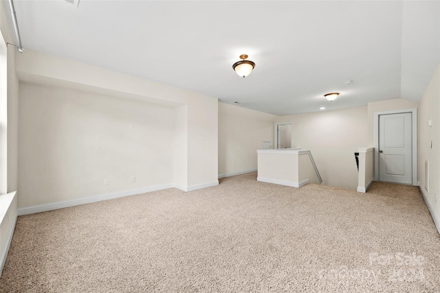 carpeted spare room with vaulted ceiling