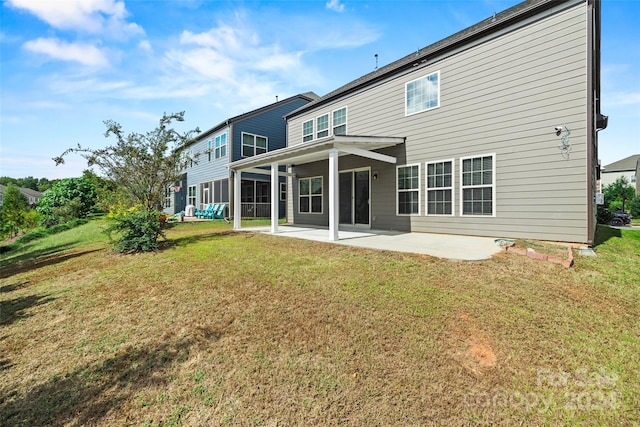 rear view of property featuring a lawn and a patio