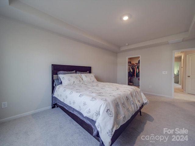 bedroom featuring a spacious closet, a closet, and light carpet