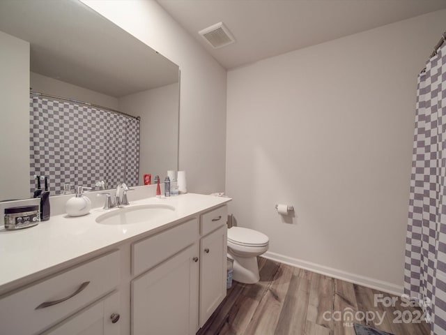 bathroom with vanity, toilet, and hardwood / wood-style flooring