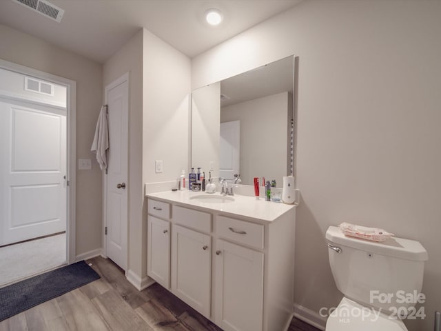 bathroom with vanity, hardwood / wood-style floors, and toilet