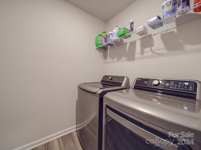 laundry room with hardwood / wood-style floors and independent washer and dryer