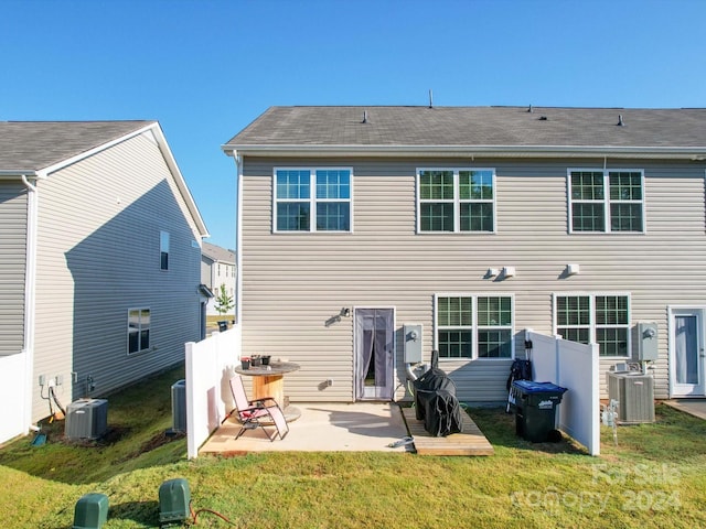 rear view of house with a yard, a patio, and central AC