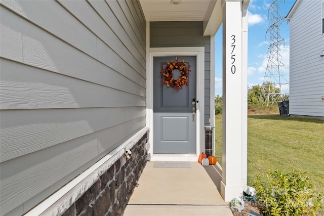 view of exterior entry with a yard