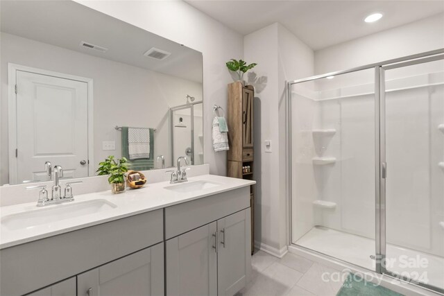 bathroom with vanity, a shower with door, and tile patterned floors