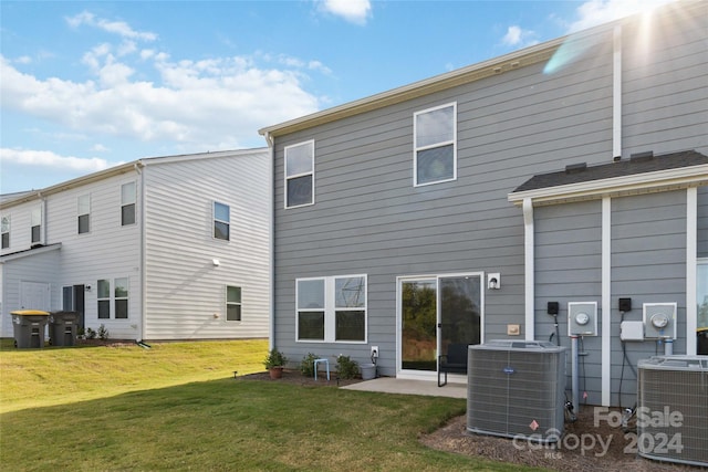 rear view of property with central AC unit, a yard, and a patio