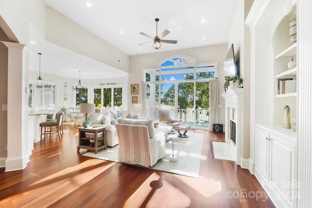 living room with hardwood / wood-style flooring and ceiling fan with notable chandelier