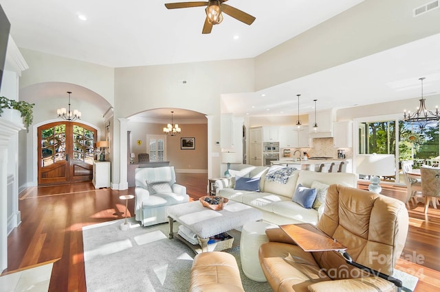 living room with ceiling fan, sink, a high ceiling, light wood-type flooring, and crown molding