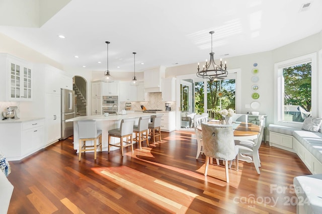 dining space with an inviting chandelier and dark hardwood / wood-style flooring