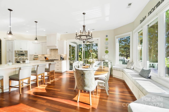 dining area with an inviting chandelier and dark hardwood / wood-style flooring