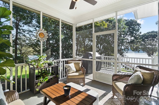 sunroom / solarium with a water view and ceiling fan