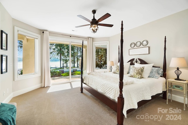 carpeted bedroom featuring access to exterior, ceiling fan, and a water view