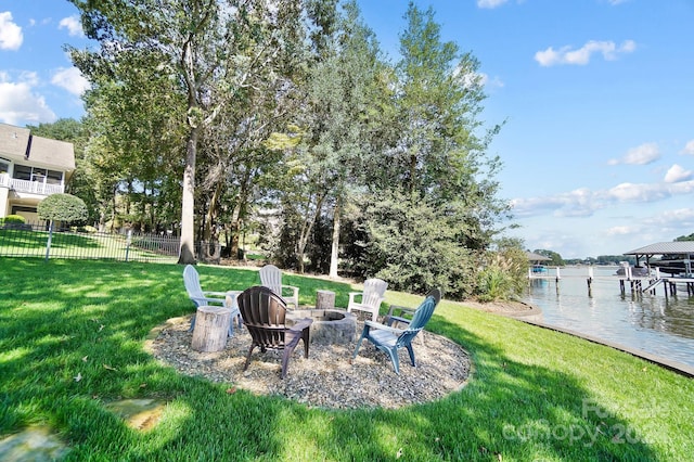 view of yard with an outdoor fire pit, a boat dock, and a water view