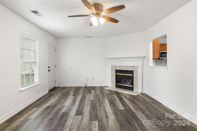 unfurnished living room with a textured ceiling, dark wood-type flooring, and ceiling fan