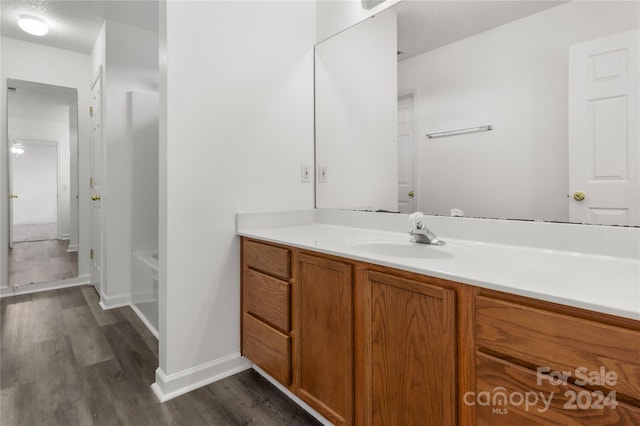 bathroom with vanity, a tub, a textured ceiling, and hardwood / wood-style floors