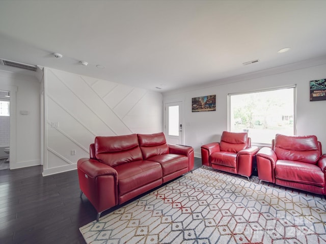 living room with dark hardwood / wood-style floors, crown molding, and a wealth of natural light