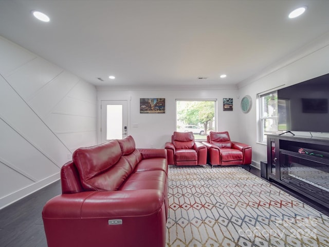 living room featuring wood-type flooring and crown molding