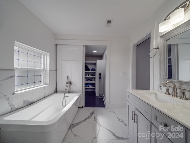 bathroom featuring vanity and a bath