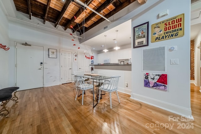 dining room with light hardwood / wood-style floors, wood ceiling, beamed ceiling, and high vaulted ceiling