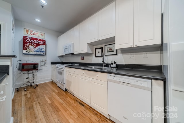 kitchen with white appliances, light hardwood / wood-style floors, white cabinetry, and sink
