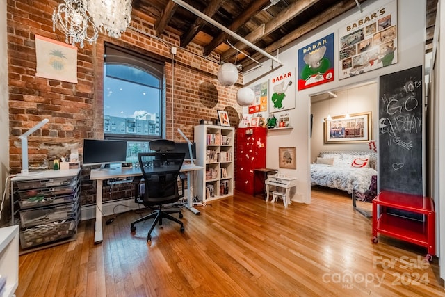 office with beamed ceiling, brick wall, and hardwood / wood-style flooring