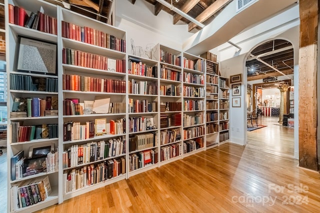 living area with beam ceiling and hardwood / wood-style floors