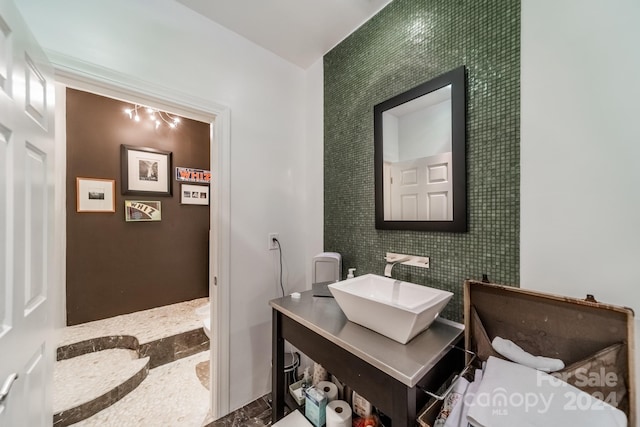 bathroom featuring vanity, tile walls, and toilet