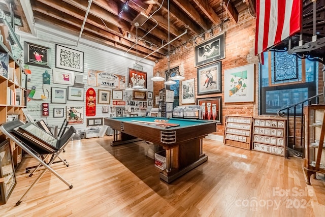 game room featuring brick wall, light hardwood / wood-style flooring, and pool table