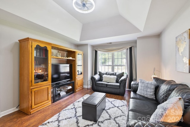 living room featuring lofted ceiling, a tray ceiling, dark hardwood / wood-style floors, and ceiling fan